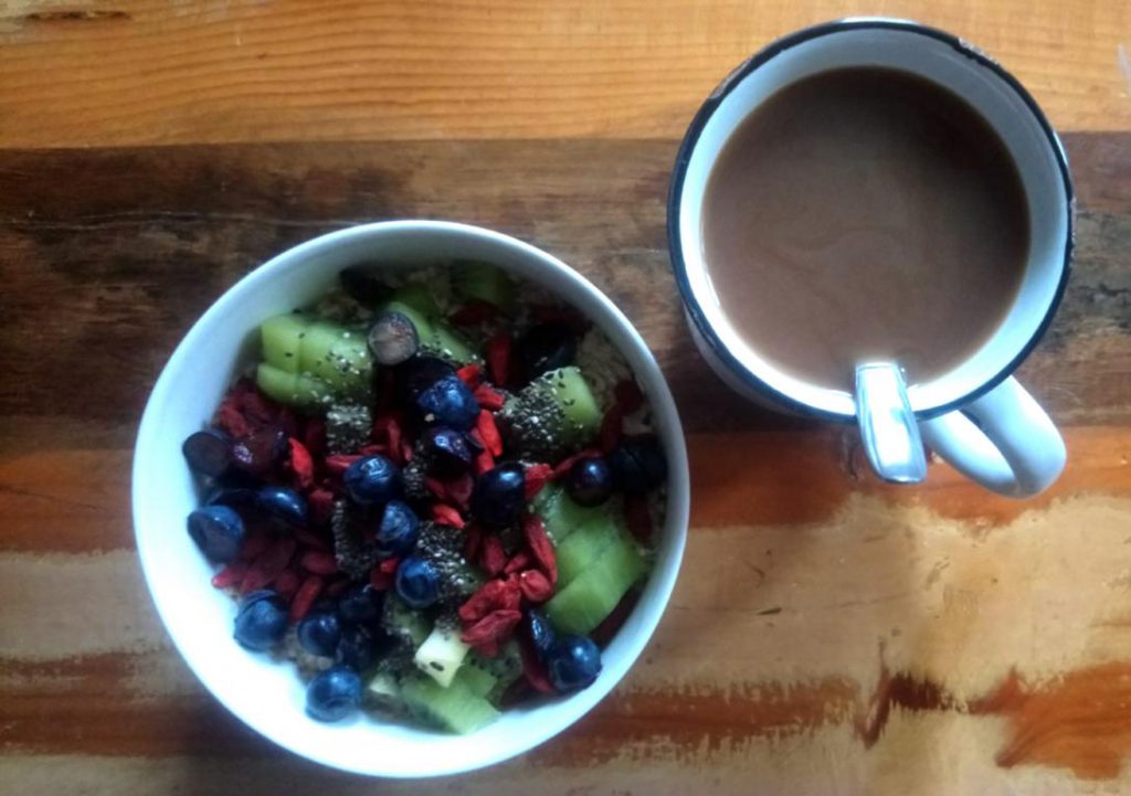 Frühstück mit Kaffe, Porridge und Obst