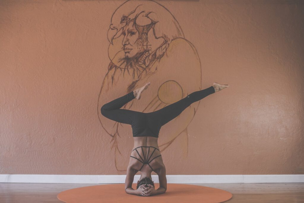 Frau macht Yoga vor einer bemalten Wand