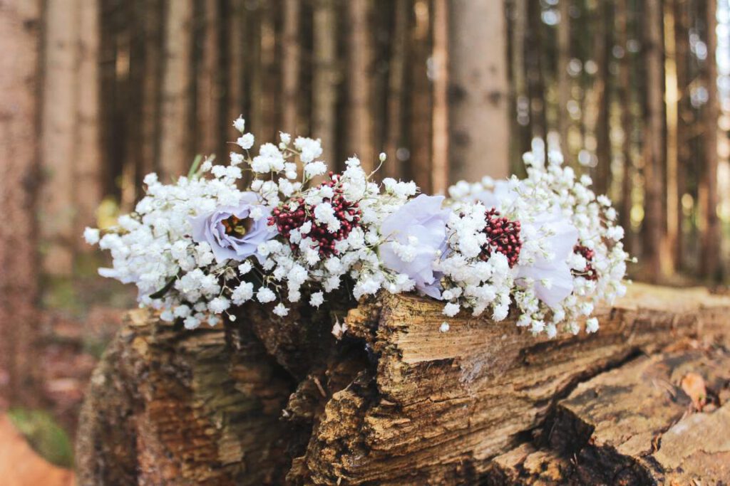 Blumenkranz, der auf einem Baumstamm im Wald liegt