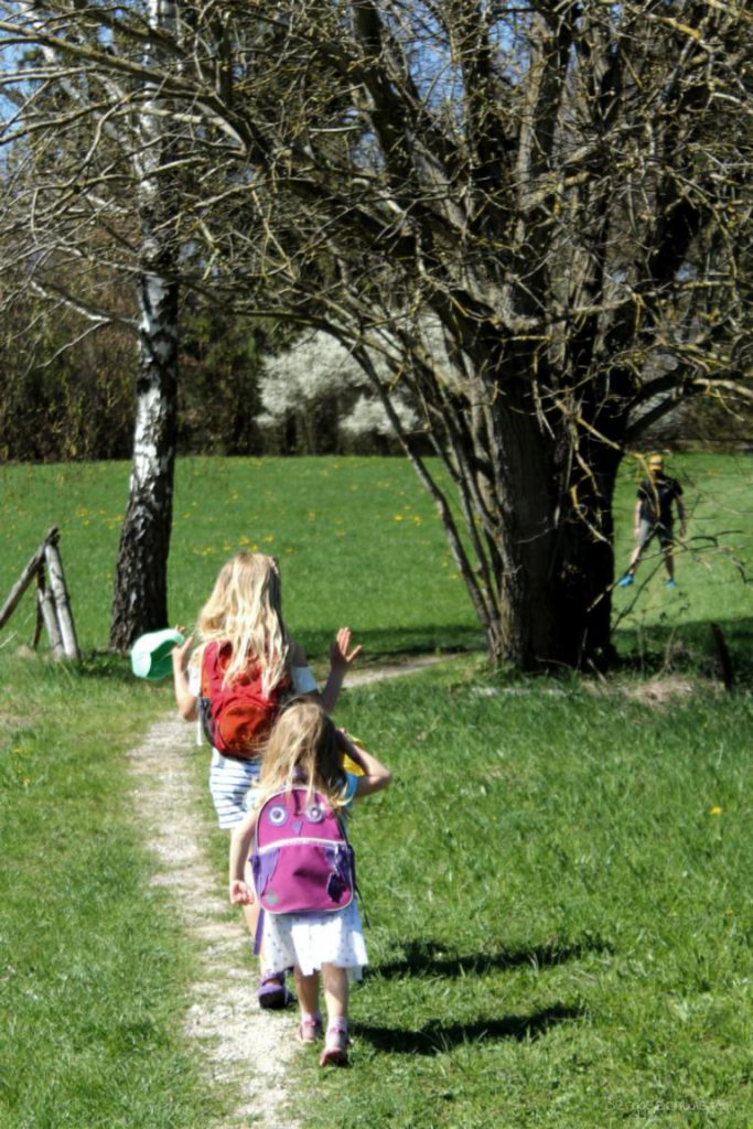 Zwei Mädchen laufen mit Osterkörben über die Wiese