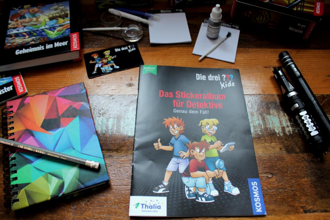 Detektivausrüstung auf einem Tisch, mittig das Sammelheft von Thalia